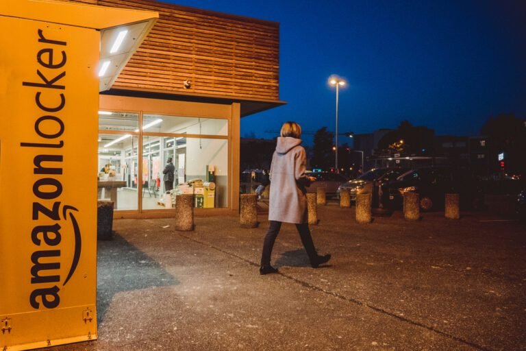 Mujer saliendo de la taquilla naranja de Amazon al anochecer | Las 3 mejores alternativas a Amazon Locker para tus entregas