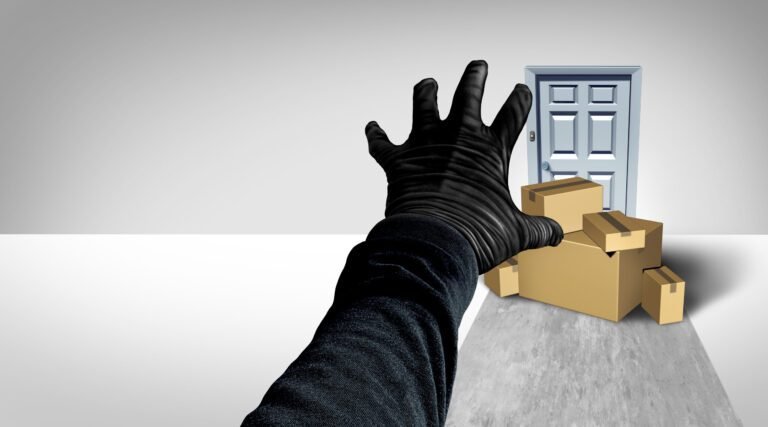 Gloved hand reaching for packages on a porch, symbolizing the threat of porch pirates.