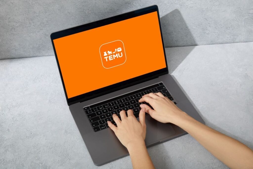 Hands are typing on a laptop, and the Temu logo, set against an orange background, is displayed on the computer screen.