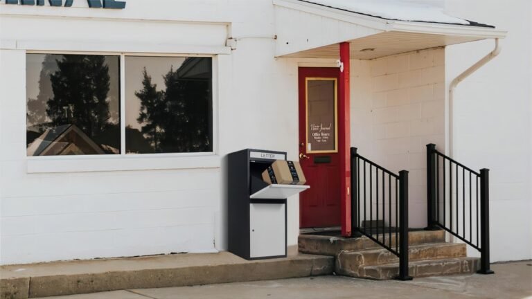 A white drop box for packages is placed beside the door.